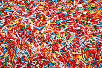 Bright colorful sprinkles as background, top view. Confectionery decor