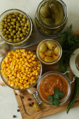 Different pickled food and ingredients on white textured background