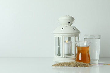 Lantern, glasses of tea and water on white background