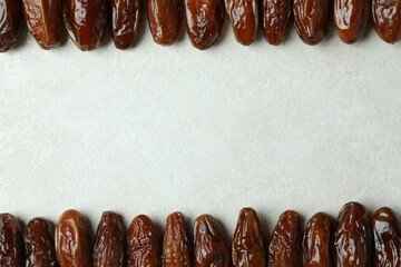 Dried dates on white textured background, space for text