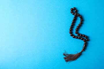 Rosary or prayer beads on blue background
