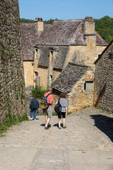 Fototapeta na wymiar Tourists in the cobbled streets of Beynac et Cazenac village, the Dordogne, France