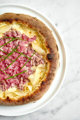 Juicy pizza with white sauce, tuna, cream cheese and ginger. Italian pizza with seafood from wood oven on wood board on marble background