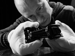 portrait of a collector of retro car models on a black background