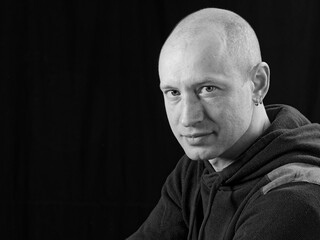 bw portrait of a bald man on a black background