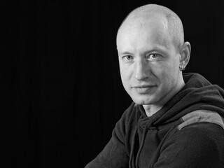 bw portrait of a bald man on a black background