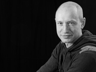 bw portrait of a bald man on a black background