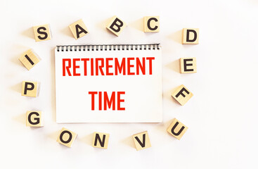Pension time written on a notebook and a white background, next to letters on cubes. The concept of retirement age