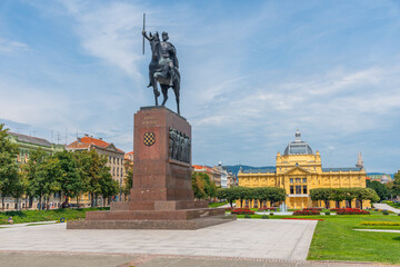 Statue of King Tomislav and yellow art pavilion  in Zagreb, Croatia