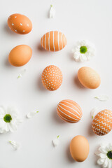 Fototapeta na wymiar Stylish Easter eggs and spring flowers on white background. Happy easter minimal concept. Flat lay, top view.