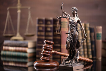Law theme. Judge chamber. Judge’s gavel, scale, Themis sculpture and collection of legal books on...