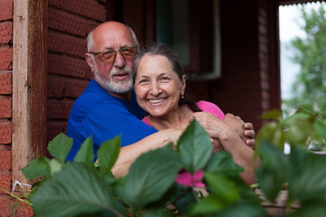Fototapeta premium Mature couple on porch of village cottage