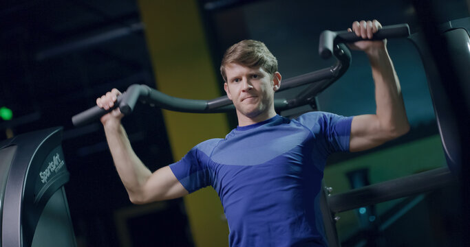Strong Handsome Male Closeup Using Pull Down Machine Upper Body Strength Exercise Sports Center Active Lifestyle Concentration Health Focused Fitness Concept - Powered by Adobe