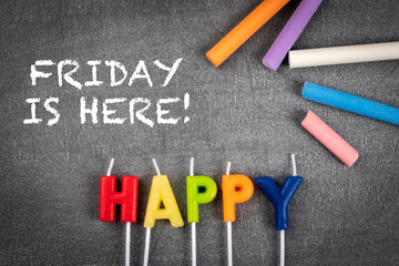 Happy, Friday is here. Colored pieces of chalk on a blackboard background