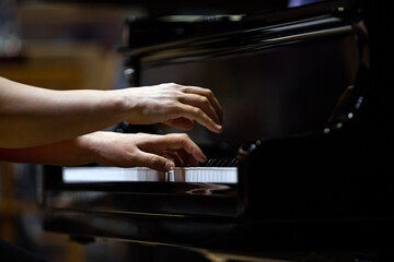 Hands of a woman playing the piano close up 