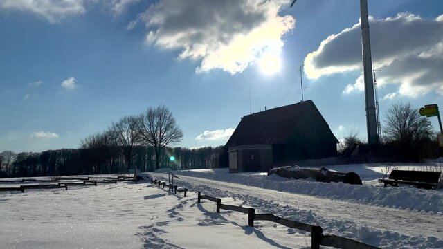 Winter Landscape With Bare Trees, House And Windmill During Daytime - tilt up shot