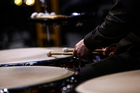 Hands of a musician playing the timpani in the orchestra close up