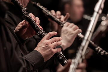 Hands of a musician playing the oboe in an orchestra - 414880846