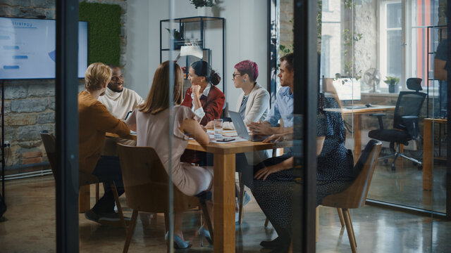 Diverse Group of Multi-Ethnic Professional Businesspeople Meeting in the Conference Room. Creative Team Discuss Design, Analyze Data, Plan Marketing Strategy for Social Media. Stylish Business Office