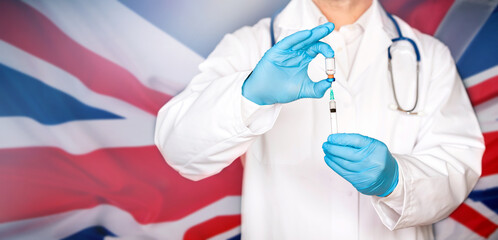 Close up of hands of doctor preparing for vaccination, UK flag in the background