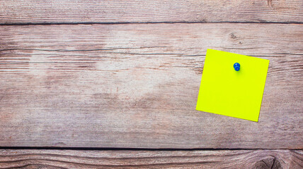 Пустая желтая цветная наклейка на деревянном фоне. Место для копирования
