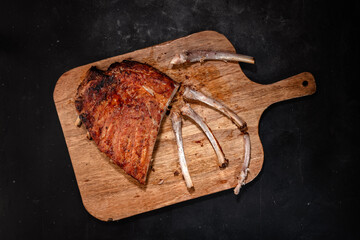 Pork ribs grilled with BBQ sauce on wooden board
