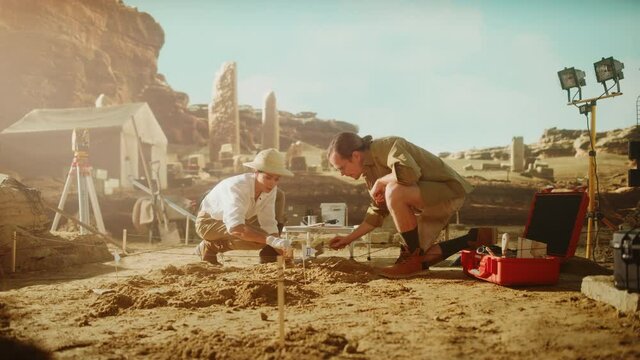 Archeological Digging Site: Two Great Archeologists Work on Excavation Site, Cleaning Cultural Artifacts with Brush and Tools. Discovery of Ancient Civilization Temple, Architecture, Fossil Remains