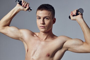 Fototapeta na wymiar handsome man with a pumped-up body dumbbells in his hands workout muscles