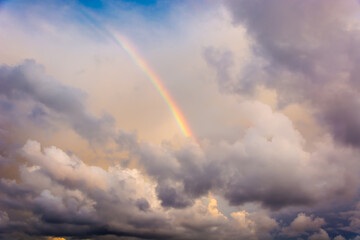 Luminous rainbow in the cloudy sky