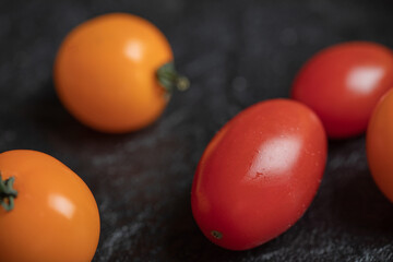 Yellow and red cherry tomatoes on a dark background