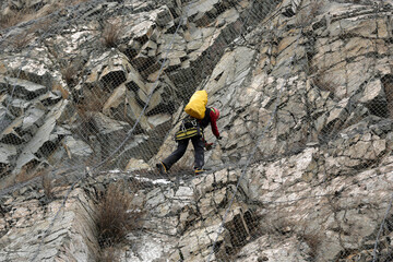 Worker climbs the safety net near the aftermath of a stone landslide at the eighth kilometer of Struma Motorway.