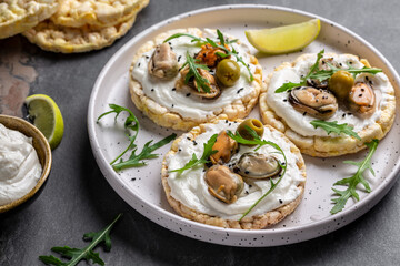 Delicious antipasti bruschetta with mussels, Crisp bread, soft cheese and arugula salad. Set of tasty appetizer sandwiches. top view