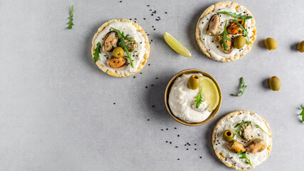 Tasty fresh bruschetta with mussels, Crisp bread, soft cheese and arugula salad. Set of tasty appetizer bruschetta. Long banner format, top view