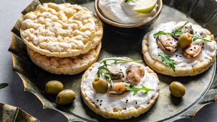 Crisp bread healthy snack with mussels, cottage cheese and arugula. Easy breakfast concept close-up