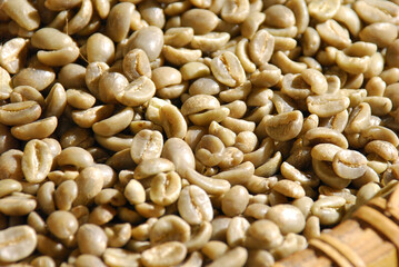 Green coffee beans in woven bamboo. Focused in middle of the frame.