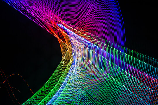 Light painting abstract background. Colored light painting photography, long exposure, ripples and swirl against a black background.