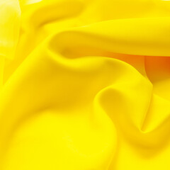 The colors of 2021 are yellow. abstract yellow fabric background. wavy folds, waves of fabric....