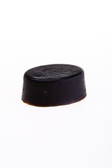 Black round piece of soap on a white background. 