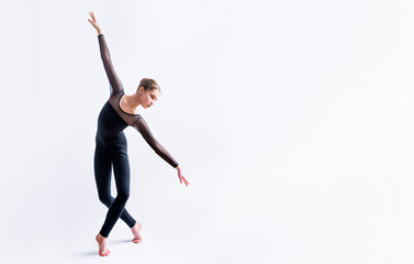 a ballet girl in a black tight-fitting suit dances on a white background with modern contemporary...