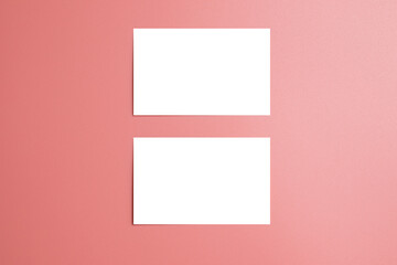 Fototapeta premium Mockup of two white business cards on a pink background. Template with space for text.