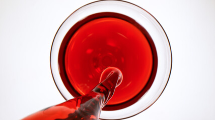 top view of pouring red wine into glass on white background