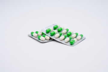 Two plates of amoxilin antibiotic capsules on a white background