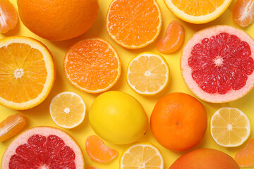 Many fresh citrus fruits on yellow background, flat lay