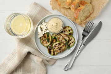 Flat lay composition with delicious grilled zucchini slices on white wooden table