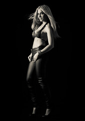Sexy blonde girl in a black bra and leather trousers posing with a confident attractive smile