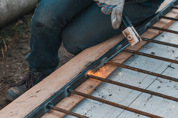 A man welds a metal frame to build an aviary, welding metal close up.