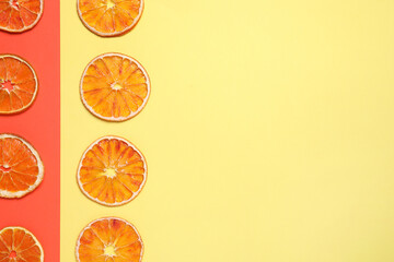 Delicious dried orange slices on color background, flat lay. Space for text