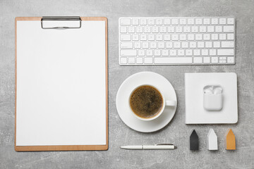 Flat lay composition with cup of coffee, computer keyboard on grey table