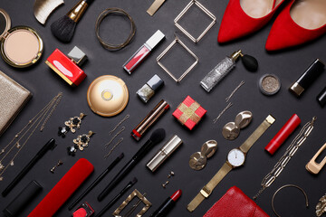 Flat lay composition with different makeup products and women's accessories on black background