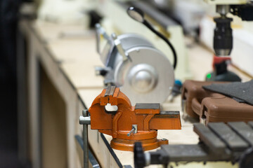 Table in the workshop with a vise. Classes at the school of technical creativity.